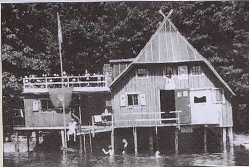 Historische Schwarzweißaufnahme des alten Bootshauses auf Pfählen